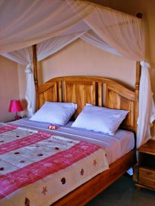 a bedroom with a large bed with a canopy at Acarya Bungalows Amed in Amed