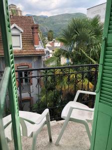 two white chairs sitting on a balcony with a view at Hotel Villa Plaisance in Lourdes