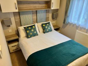 a small bedroom with a bed with two pillows at 3 Bedroom Caravan MC37, Shanklin, Isle of Wight in Shanklin