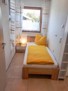 a small bedroom with a bed with a window at Ferienwohnungen Herbst in Obing