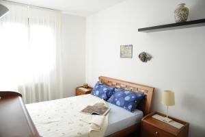 CasièrにあるMorandin Apartmentのベッドルーム1室(青い枕のベッド1台、窓付)