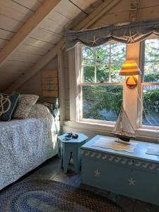 una camera da letto con un letto e un tavolo con una lampada di Compass Rose a Boothbay Harbor