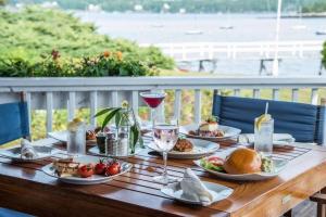 un tavolo in legno con piatti di cibo e bicchieri di vino di Compass Rose a Boothbay Harbor