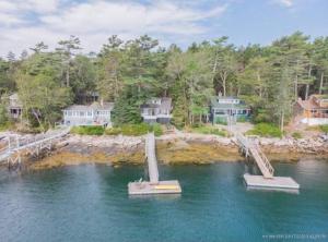 una vista aerea di una casa con due statue nell'acqua di Compass Rose a Boothbay Harbor