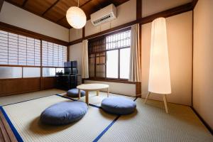 a room with blue pillows and a table and windows at Kizuna House Yuzuriha in Minamiawaji