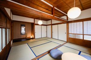 an empty room with a room with blue mats on the floor at Kizuna House Yuzuriha in Minamiawaji