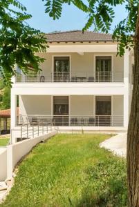 a house with a lawn in front of it at Δωμάτια Κωσταφάκας Κοκκινοπηλός Ολύμπου in Kokkinopilós