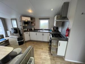 a kitchen with a sink and a stove top oven at 3 Bedroom Caravan MC37, Shanklin, Isle of Wight in Shanklin