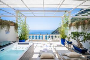 a hot tub in a room with a view of the ocean at Hotel Villa Gabrisa in Positano
