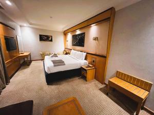 メッカにあるMaysan Al Maqam Hotelの大型ベッドとベンチ付きのホテルルームです。 +67枚の写真