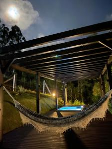 a hammock in a backyard with a pool at Chalé rural- hospedagem e experiência! in Gaspar