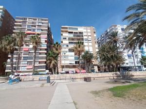 a park with palm trees in front of tall buildings at Mediterranean vibes in Málaga