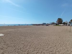 a sandy beach with a group of people and the ocean at Mediterranean vibes in Málaga