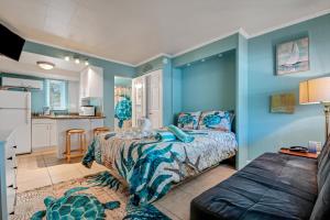 a bedroom with blue walls and a bed and a kitchen at Tropic Terrace Suite #4 - Beachfront Resort in St Pete Beach