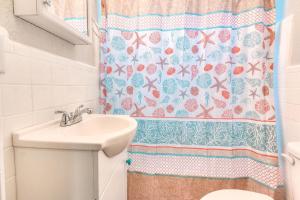 ein Badezimmer mit Waschbecken und Duschvorhang in der Unterkunft Tropic Terrace Suite #49 - Beachfront Resort in St Pete Beach