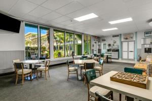 ein Esszimmer mit Tischen und Stühlen und Fenstern in der Unterkunft Tropic Terrace Suite #39 - Beachfront Resort in St Pete Beach