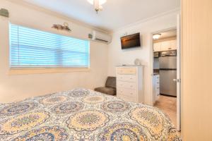 a small bedroom with a bed and a kitchen at Tropic Terrace Suite #51 - Beachfront Resort in St Pete Beach +19 photos
