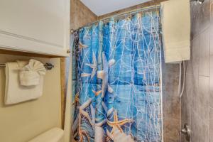 a bathroom with a shower curtain with a painting of tentacles at Tropic Terrace Suite #48 - Beachfront Resort in St Pete Beach +21 photos