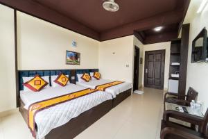 a bedroom with a large bed with colorful pillows at Khách Sạn Nhân Đức - Sầm Sơn in Sầm Sơn