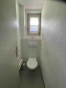 Un pequeño baño con inodoro y ventana. en Swiss Alpine Hideaway, en Sedrun