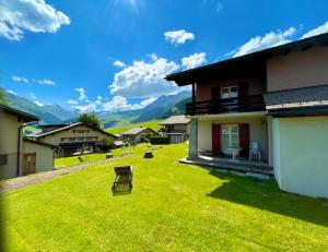 un patio de una casa con una silla en el césped en Swiss Alpine Hideaway, en Sedrun