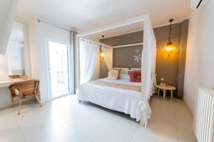 a bedroom with a canopy bed and a desk at Hotel Tarongeta - Adults Only in Cadaqués