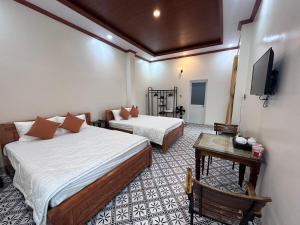 a hotel room with two beds and a tv at Homestay Mai Ngọc Tây Ninh in Tây Ninh