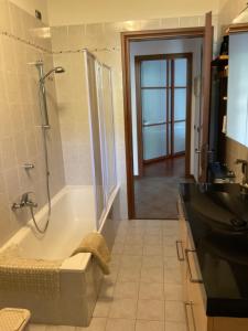 a bathroom with a tub and a shower and a sink at Appartamento al lago in Corgeno +13 photos