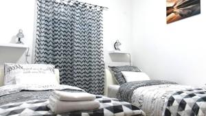 two beds in a bedroom with black and white at Comfortable four-room apartment in Beli Manastir