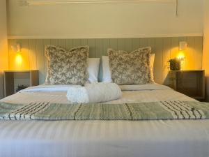 a large bed with white sheets and pillows at The Highlander Motel - 24HR Check In in Maryborough