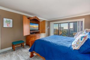 a bedroom with a blue bed and a window at Sand Key South Beach Condo #910 in Clearwater Beach