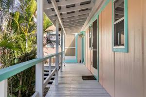 a walkway leading to a house with palm trees at Goodland Waterfront Cottage in Goodland