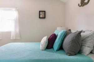 a bed with a bunch of pillows on it at Goodland Waterfront Cottage in Goodland