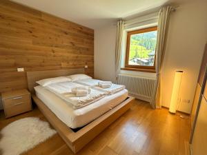 巴德小基希海姆REHKITZ Apartment的一间卧室设有一张带木墙的大床