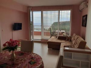 a living room with a couch and a large window at The Seaview jacuzzi Suite complex Karia in Kavarna