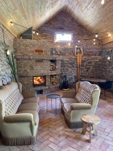 a living room with two couches and a fireplace at Slow Home in Dziemiany