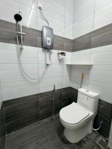 a bathroom with a white toilet and a shower at 390 Kurau in Kuala Kurau
