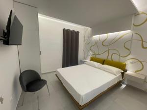 a bedroom with a bed and a chair and a television at Residenza Leonina in San Martino in Pensilis