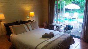 a bedroom with a bed with a teddy bear on it at Luilekker Chalets in Waterval-Onder