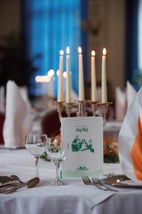 una mesa con dos copas de vino y velas en Hotel Sauerbrey, en Osterode