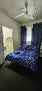a bedroom with a bed with a blue comforter at Meyenburg Units in Mount Morgan