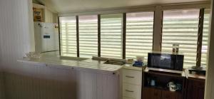 a kitchen with a counter with a tv and some windows at Meyenburg Units in Mount Morgan +116 photos