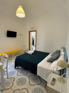 une chambre avec un lit, une télévision et une table dans l'établissement Il Vicoletto, à Amalfi