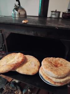 two pizzas sitting on top of a grill at Tebdi Qor, Warm Home in Mestia