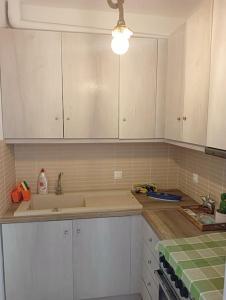 a kitchen with white cabinets and a sink at Porto Anafi in Anafi +23 photos