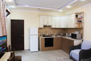 a kitchen with white cabinets and a white refrigerator at SD House in Dilijan