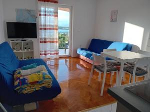 a living room with a blue couch and a table at Apartment Mario 2 in Klimno