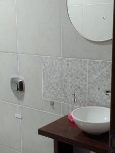 Un baño con un lavabo blanco y un espejo. en Departamentos M&A 1, en Puerto Rico