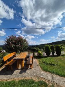 a wooden picnic table and benches in a park at Guesthouse Milka in Poljanak