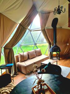 a living room with a couch and a large window at Žvaigždžių slėnis - Kupolai in Sližiai